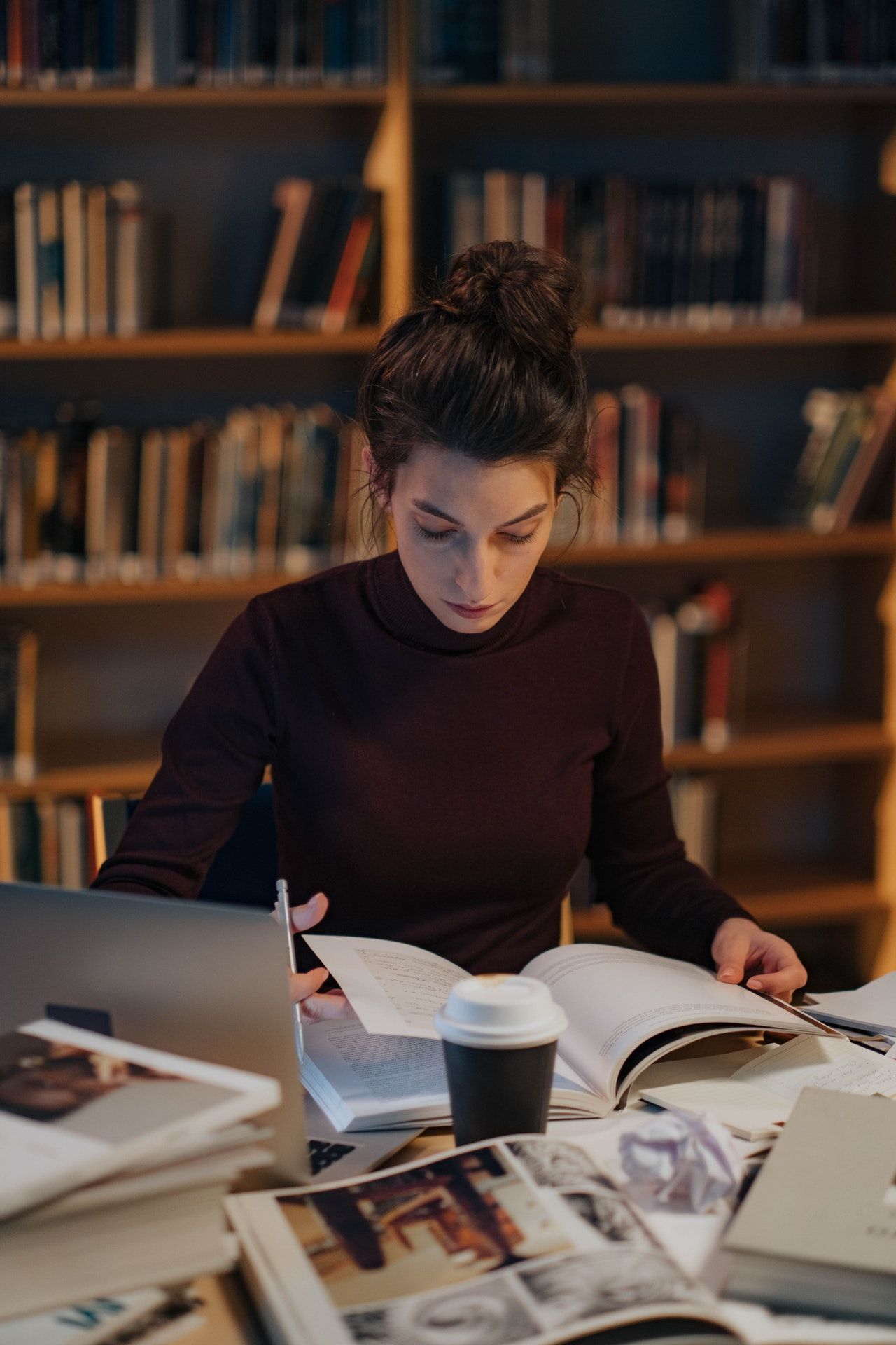 Estudiante revisando libros en una biblioteca